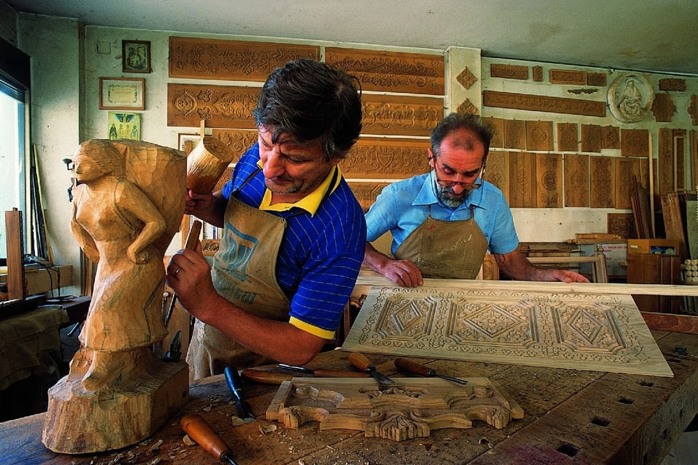 Artigiani carnici al lavoro nella lavorazione del legno, tradizione artigianale del Friuli Venezia Giulia