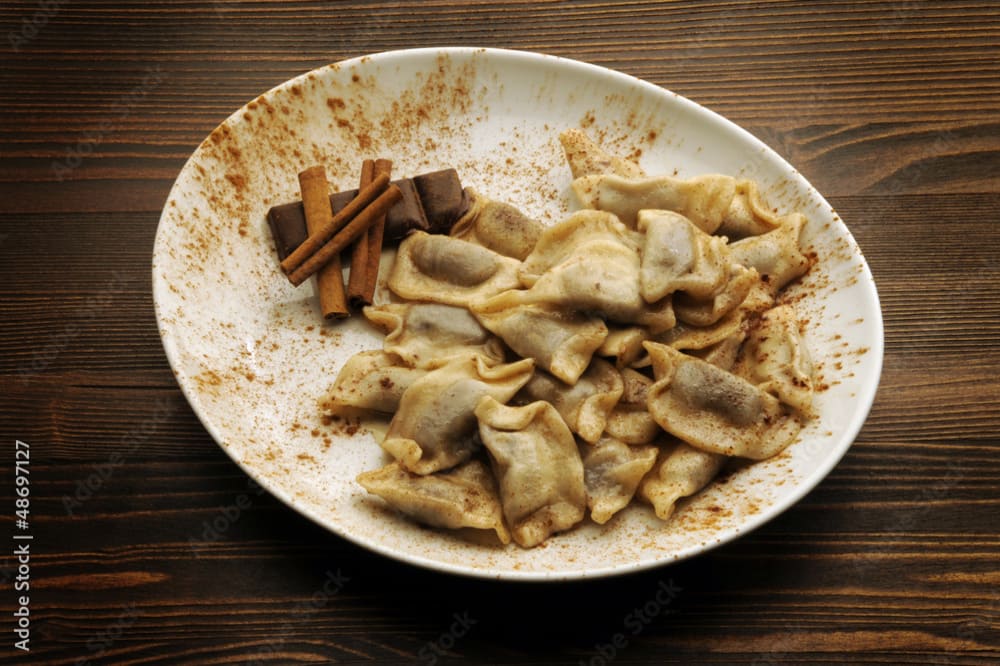 Piatto di cjarsòns, tipici ravioli della Carnia, serviti con burro fuso e erbe aromatiche